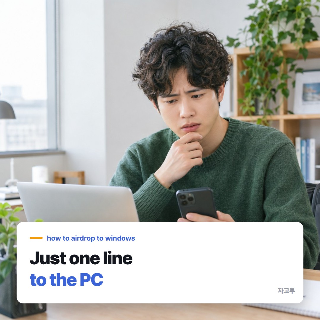Someone holding an iPhone next to a Windows laptop at a desk